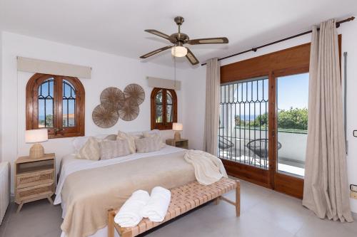a bedroom with a bed and a large window at Villa Carmen - Peaceful Eco-Luxury with private pool in Cunit