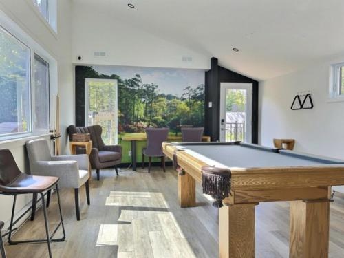 a living room with a pool table and chairs at Le Carpe Diem in Pont-Rouge