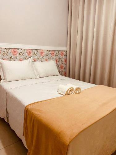 a bed with two gold wedding rings on it at Apto Suite Aconchegante a 03 minutos do Bairro Horto in Coronel Fabriciano