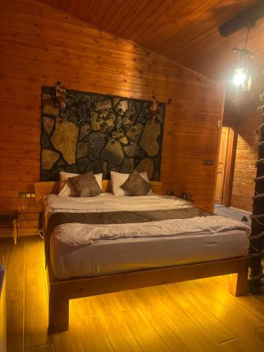 a bedroom with a bed with a stone wall at Ayder Luxury Villas & Bungalows in Çamlıhemşin
