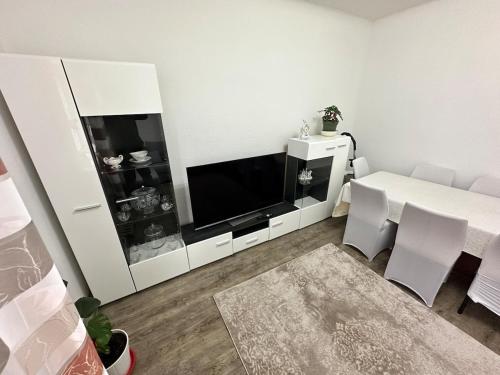 a living room with a tv and a table with chairs at Easy Stay Room for Two in Nürnberg