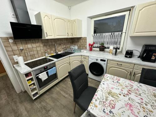 a kitchen with white cabinets and a sink and a table at Easy Stay Room for Two in Nürnberg