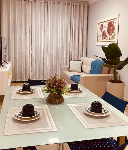 a living room with a table with cups and plates on it at Apto Suite Aconchegante a 03 minutos do Bairro Horto in Coronel Fabriciano