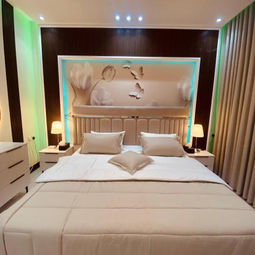 Un dormitorio con una gran cama blanca y dos lámparas. en شقة جديدة ديكور فخم مدخل ذكي, en Taif