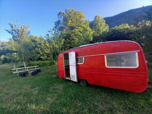 a red trailer is parked in a field at Kamp kucice 
