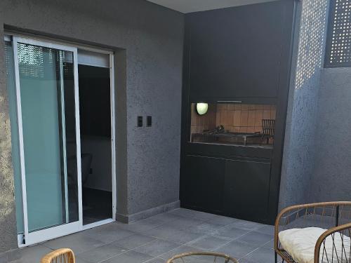 a kitchen with a sliding glass door with a sink at Nova Suites , a estrenar con asador y cochera privada in Villa Mercedes