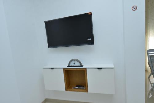 a living room with a tv on the wall at Dar Hella Apartments in El Maamoura