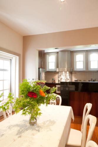 a kitchen with a table with a vase of flowers on it at Lowena Cafe and Accommodation in Hobart