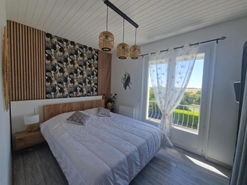 une chambre avec un grand lit et une grande fenêtre dans l'établissement Villa Haut de gamme 