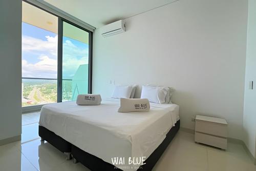 ein Bett in einem Zimmer mit einem großen Fenster in der Unterkunft Wai Blue/Luxury Beachfront/ Bello Horizonte/ TTO03 in Playa Dormida