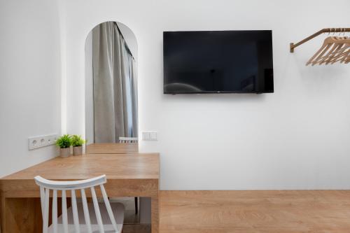 a dining room with a table and a tv at Secret Garden Studios in Mytilini