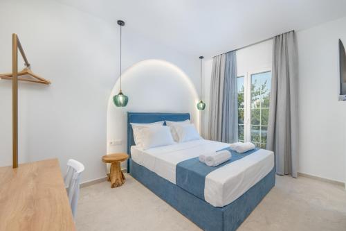 a bedroom with a bed and a large window at Secret Garden Studios in Mytilini