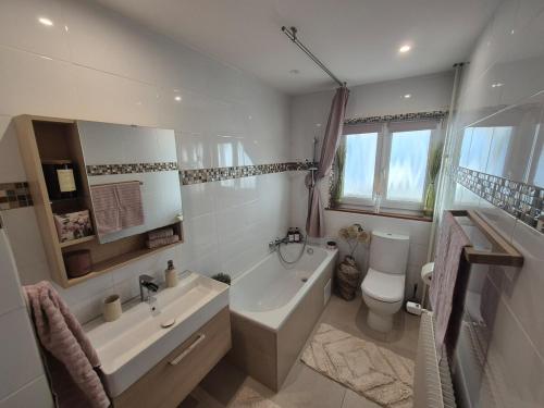 a bathroom with a tub and a sink and a toilet at Escapade saint louis Basel in Saint-Louis