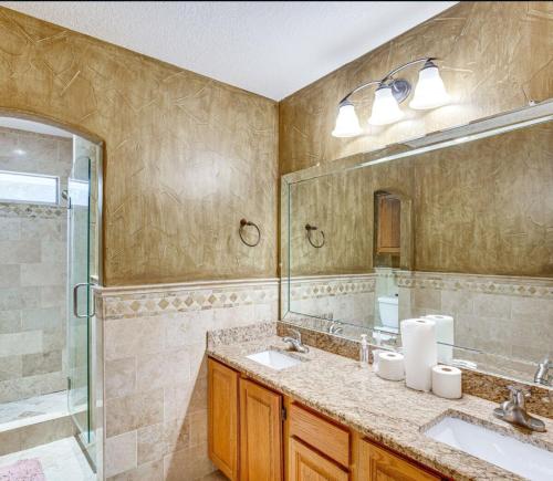 a bathroom with two sinks and a shower at 5 BR House with heated pool near DFW and stadium in Grand Prairie