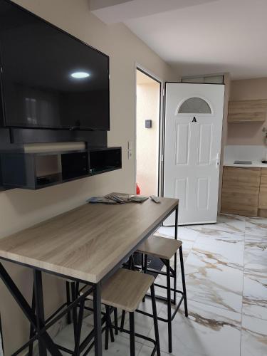 a kitchen with a wooden table and some chairs at Evasion Romantique&Jacuzzi! in Pruniers