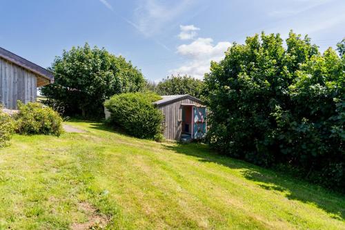 a view of a yard with a shed and trees at Spacious Farmhouse Retreat with Hot Tub, sleeps 12 in Llawhaden