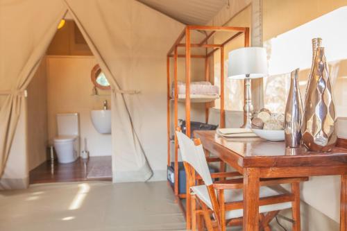 a room with a desk and a table with a mirror at Wildebeest Eco Camp in Nairobi