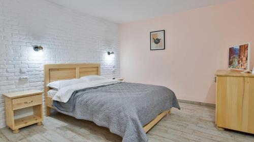 a bedroom with a bed and a white brick wall at Casa Zânelor Slănic Moldova in Slănic-Moldova