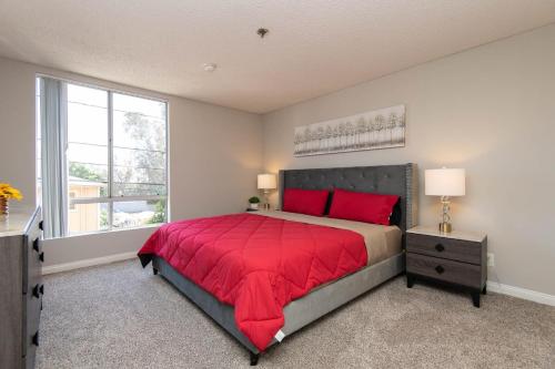 a bedroom with a red bed and a window at Modern Hollywood Apt Rooftop Pool & Skyline Views in Los Angeles