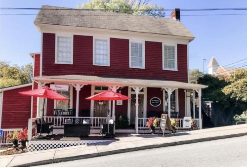 Una casa roja con dos sombrillas delante de ella. en The Dahlonega Square Hotel, en Dahlonega