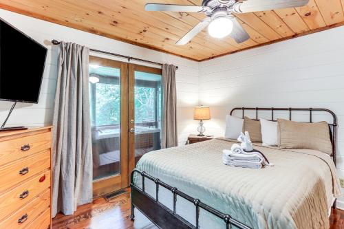 a bedroom with a bed and a flat screen tv at Picturesque Mountain Cabin with Hot Tub and Fire Pit! in Blue Ridge