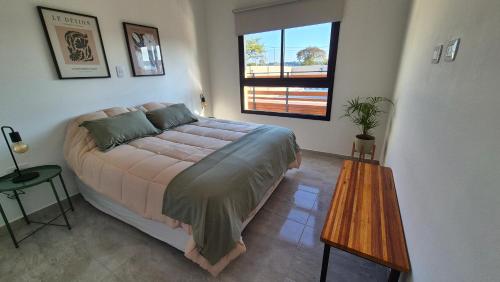 a bedroom with a bed and a table and a window at MONACO Departamento PB in Federación