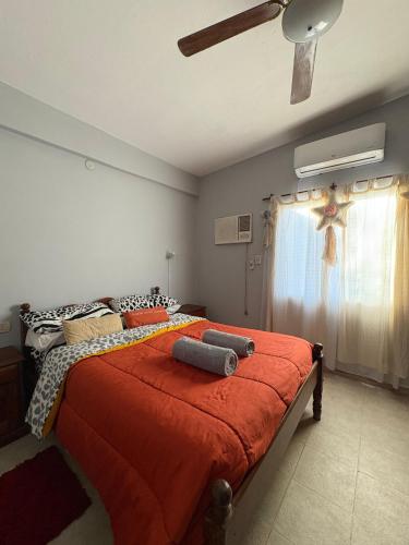 une chambre avec un grand lit avec une couverture orange dans l'établissement La Parcela, à Recreo