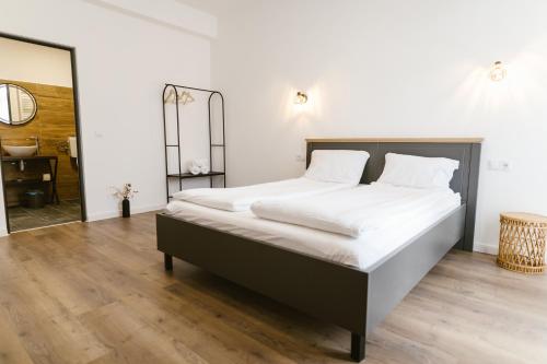 a bedroom with a large bed with white sheets at Pensiunea Arkara in Târgu-Mureş