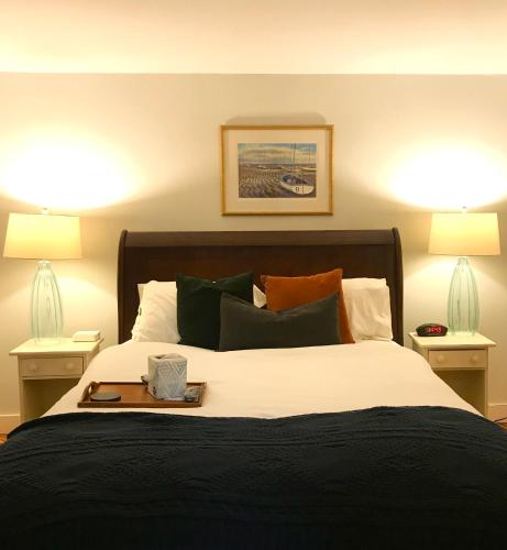 a bedroom with a large bed with two lamps at Sea Meadow Inn in Brewster
