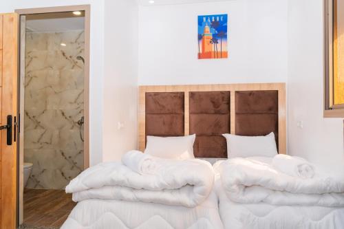 a bedroom with a bed with white towels on it at Tifawine Stay Guest House Social Stay and Oceanview Rooms in Imsouane