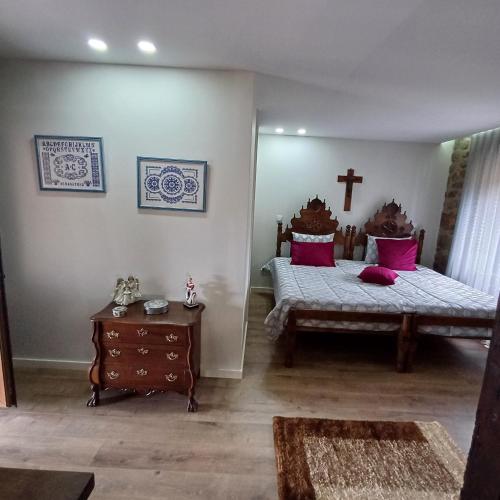a bedroom with two beds and a cross on the wall at Casa Oliveira in Barreiros