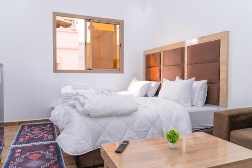 a bedroom with a large white bed and a couch at Tifawine Stay Guest House Social Stay and Oceanview Rooms in Imsouane