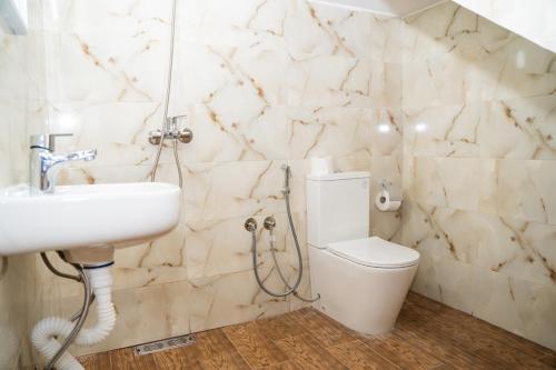 a bathroom with a white toilet and a sink at Tifawine Stay Guest House Social Stay and Oceanview Rooms in Imsouane