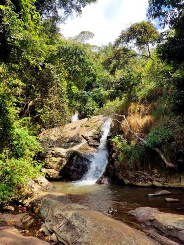 una cascata in mezzo a un fiume in una foresta di Olimpos camping a Morogoro