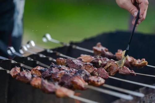 una persona está cocinando carne en una parrilla en Paratiisi Camping, en Jälist