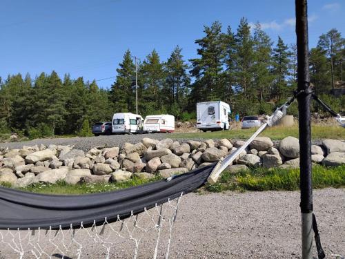Una hamaca frente a un estacionamiento con vehículos estacionados. en Paratiisi Camping, en Jälist