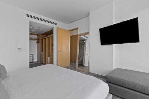 a bedroom with a bed and a tv on a wall at Comfy 3BR, near the beach in Cancún