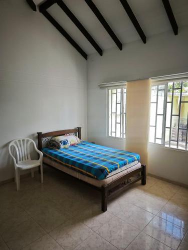 a bedroom with a bed and a chair in it at Casa Descanso in Tunía