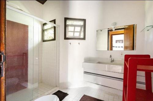 ein weißes Badezimmer mit Waschbecken und Dusche in der Unterkunft Casa Juréia com piscina aquecida, a 350m da praia - Litoral Norte in São Sebastião