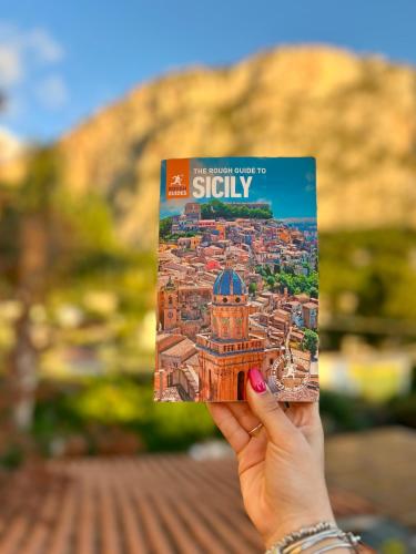 a person holding up a book about stirify at Sikelìa Bed & Breakfast in Carini