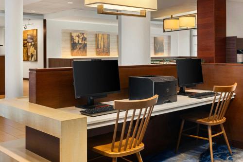 a desk with two computer monitors and two chairs at Fairfield Inn & Suites by Marriott La Crosse Downtown in La Crosse