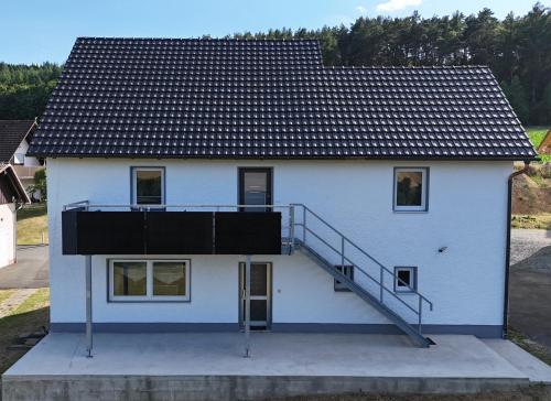 a white house with a staircase on it at Ferienwohnung Naturtraum in Mistelgau