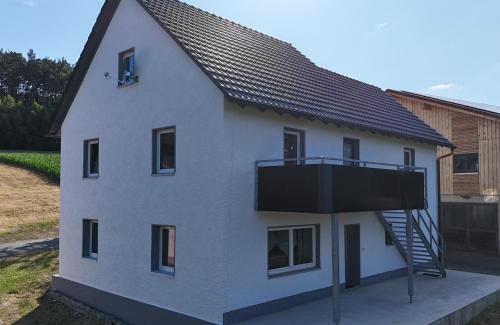 a white house with a balcony on the side of it at Ferienwohnung Naturtraum in Mistelgau