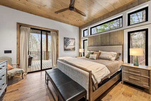 a bedroom with a large bed and windows at sugar mountain lodge in Blue Ridge