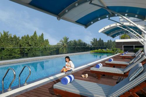 a little girl sitting next to a swimming pool at Fairfield by Marriott Belagavi in Belgaum