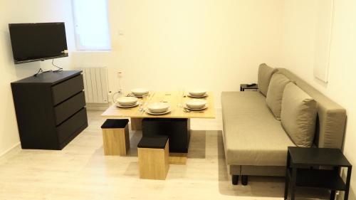 a living room with a couch and a table at Résidence Coeur de Lourdes in Lourdes