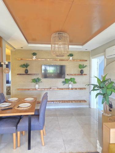 a dining room with a table and a tv at Blue Bay Village Appartement Cocooning en Rez-de-Jardin avec Vue Mer dans une Résidence Sécurisée à Moulay Abdallah près El Jadida in Moulay Abdallah