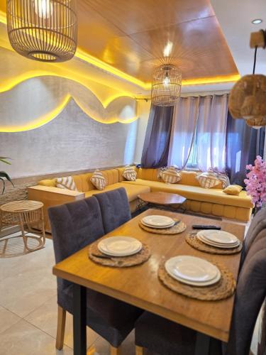 a living room with a table and a couch at Blue Bay Village Appartement Cocooning en Rez-de-Jardin avec Vue Mer dans une Résidence Sécurisée à Moulay Abdallah près El Jadida in Moulay Abdallah
