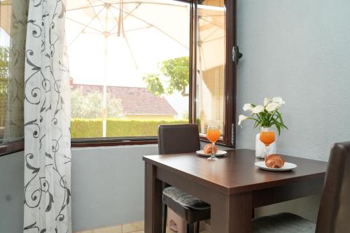 a dining room table with a window and a table with oranges at Apartments Bućin in Kotor
