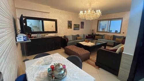 a living room with a couch and a dining room at BEAU TRIPLEX EN RESIDENCE in Skhirat